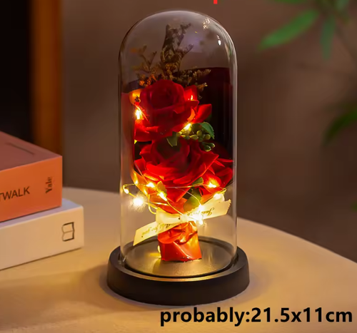 Red rose inside a glass dome with LED lights on a table